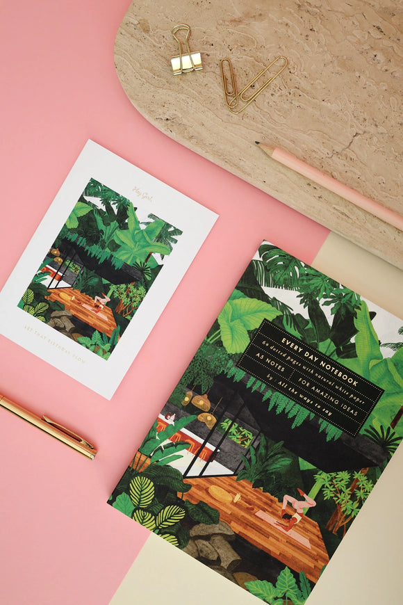 Yoga retreat illustrated notebook styled with gold pen, clips, and postcard on pink background for creative stationery flatlay.