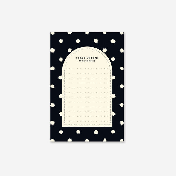A notepad with a black cover featuring vibrant painted dots and a Cream colored paper inside.