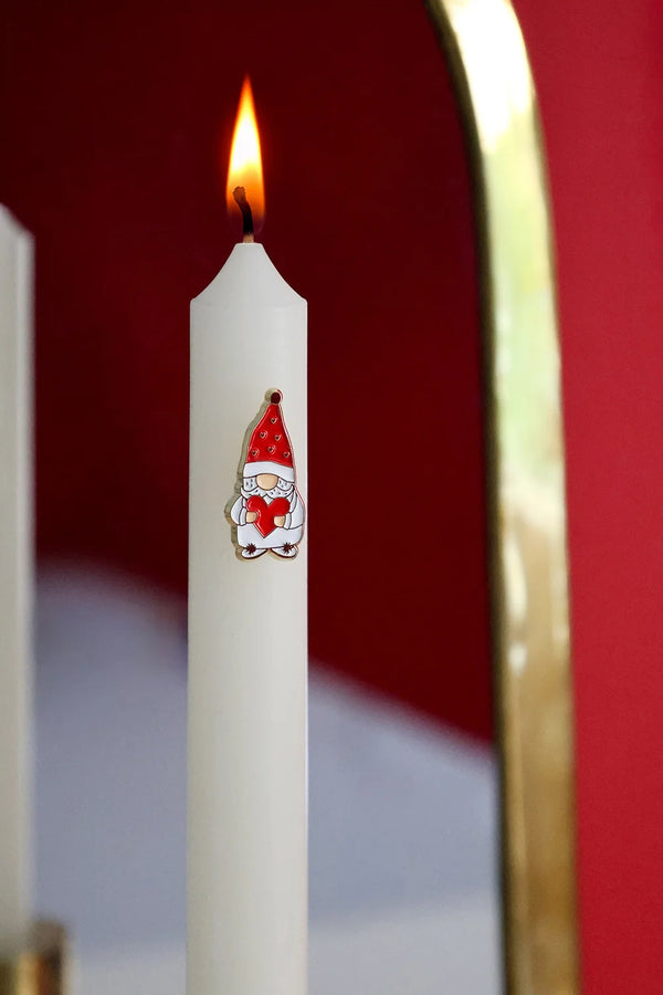 Grumpy Heart enamel pin by All The Ways To Say on lit candle with red wall and golden mirror reflection – cozy holiday scene
