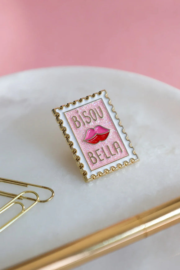 Close-up of Bisou Bella enamel pin by All The Ways To Say – pink glitter finish and red lips design on gold frame