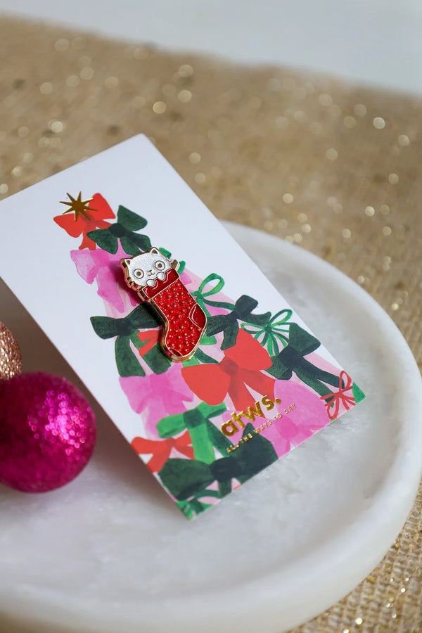 Cat Sock enamel pin on colorful Christmas card by All The Ways To Say – festive flatlay with pink and gold ornaments