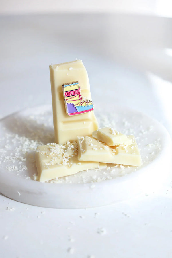 Cold AF enamel pin by All The Ways To Say – colorful moonboot design on white chocolate with coconut shavings