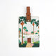 Luggage tag with Palm Springs-inspired illustration featuring tall palm trees and a mid-century house.