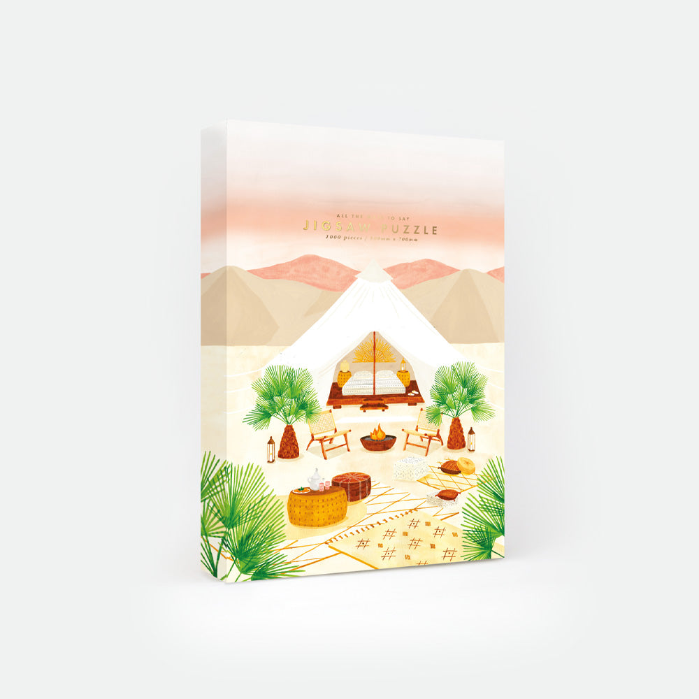 Glamping Escape jigsaw puzzle by All the Ways to Say – desert tent surrounded by palm trees, woven rugs, and warm golden tones.