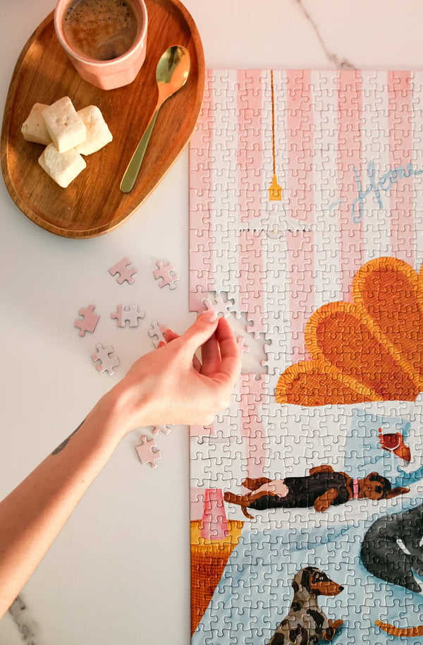 Top view of coffee and puzzle pieces while assembling the Home Sweet Home jigsaw puzzle