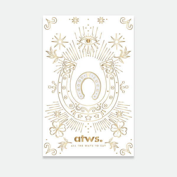 A pack of two gold-plated enamel pins with a horseshoe design and decorative elements, predominantly in gold color, against a white background.