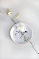Decorative round tray with a Dalmatian print surrounded by plants, coffee cup and gold accessories — All the Ways to Say home decor.