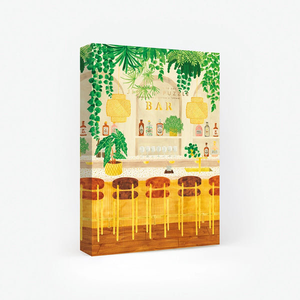 1000-piece jigsaw puzzle box by All The Ways To Say featuring a sophisticated bar scene with lush hanging plants and golden decor.