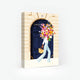 1000-piece jigsaw puzzle box by All The Ways To Say featuring a woman carrying a massive floral bouquet in front of a grand navy blue Parisian door.