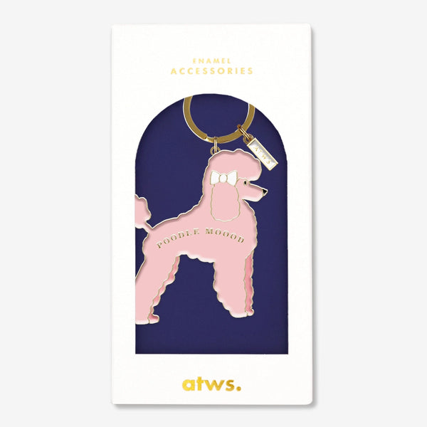 A stylish pink poodle keychain by All The Ways To Say with a gold enamel finish and the text "POODLE MOOOD", presented in an elegant gift box.