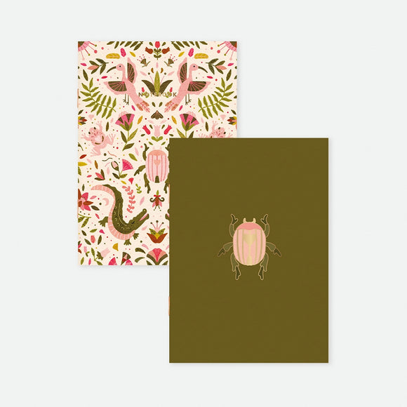 A set of two A6 pocket notebooks by All The Ways To Say: one with a botanical pattern of pink crocodiles and frogs, the other olive green with a centered gold foil beetle.