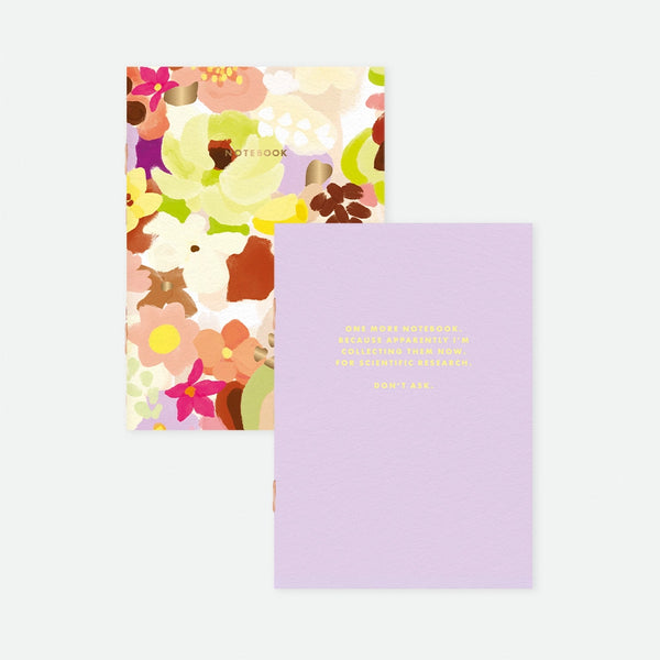A set of two A6 pocket notebooks by All The Ways To Say: one with a colorful floral pattern and gold foil, the other lilac with a humorous quote about collecting notebooks.