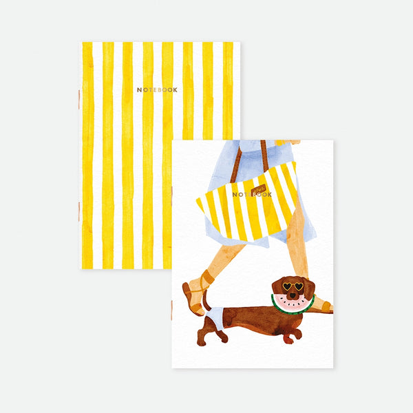 A set of two A6 pocket notebooks by All The Ways To Say: one with yellow stripes, the other featuring a dachshund with heart sunglasses and a watermelon floatie, both with gold foil.
