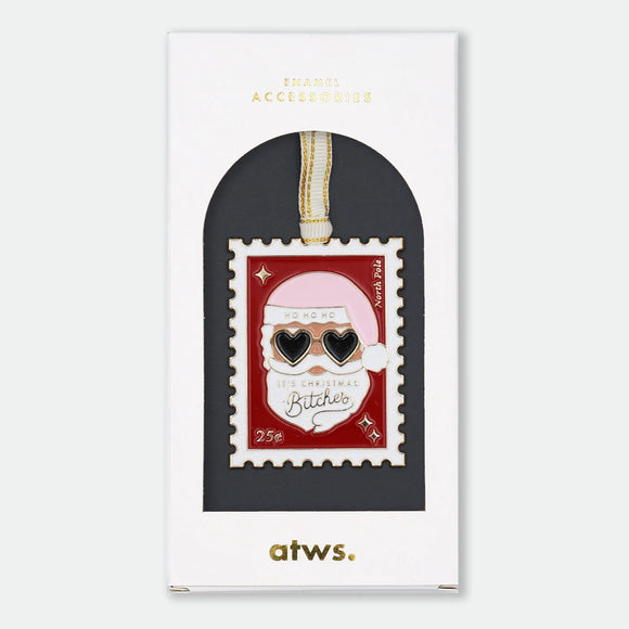Gold-tone enamel Christmas ornament shaped like a postage stamp featuring Santa Claus wearing heart-shaped sunglasses, text reading "Ho Ho Ho, It's Christmas Bitches," "North Pole," and "25¢"