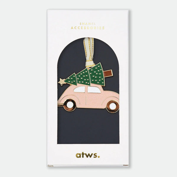 Gold-tone enamel Christmas ornament of a pink car with a Christmas tree and star strapped to the roof