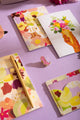 SPRING SWEETS - Collection: close-up of vibrant floral greeting cards and a pink cowboy boot enamel pin.