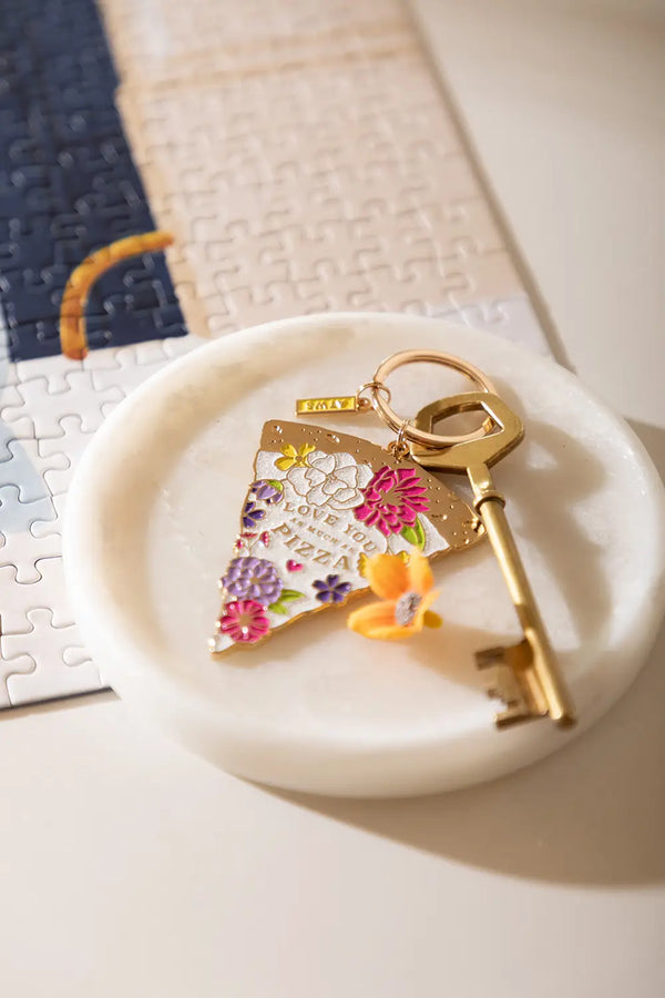 As much as pizza Keychain - Lifestyle view on a marble tray next to a puzzle.