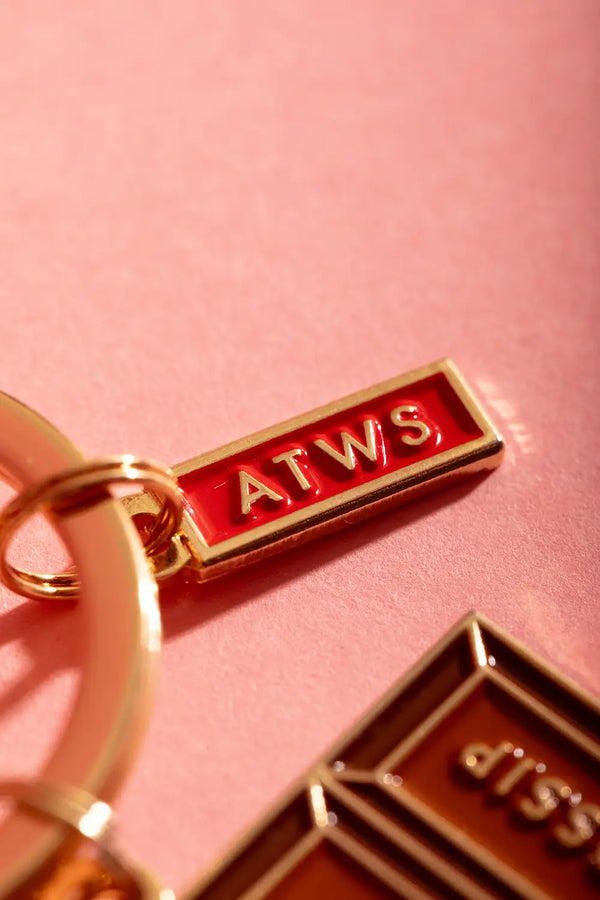Chit chat Keychain - Focus on the small red and gold ATWS logo charm on the ring.
