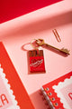 Chit chat Keychain - Red chocolate bar illustration on a pink background with a vintage key.