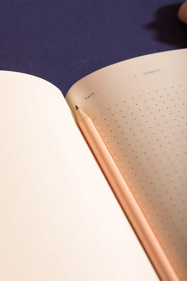 Dog(ue) Notebook A5 - Interior view of dotted pages with a pink pencil on navy background.