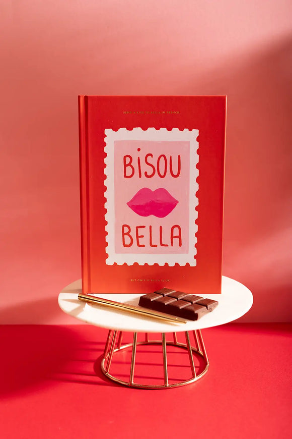 Bisou Bella Hardcover Notebook A5 - Displayed on a red background with a chocolate bar and gold pen.