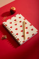 Heart Notebook Spiral - Flatlay on a red desk with a golden fountain pen and paper clips.