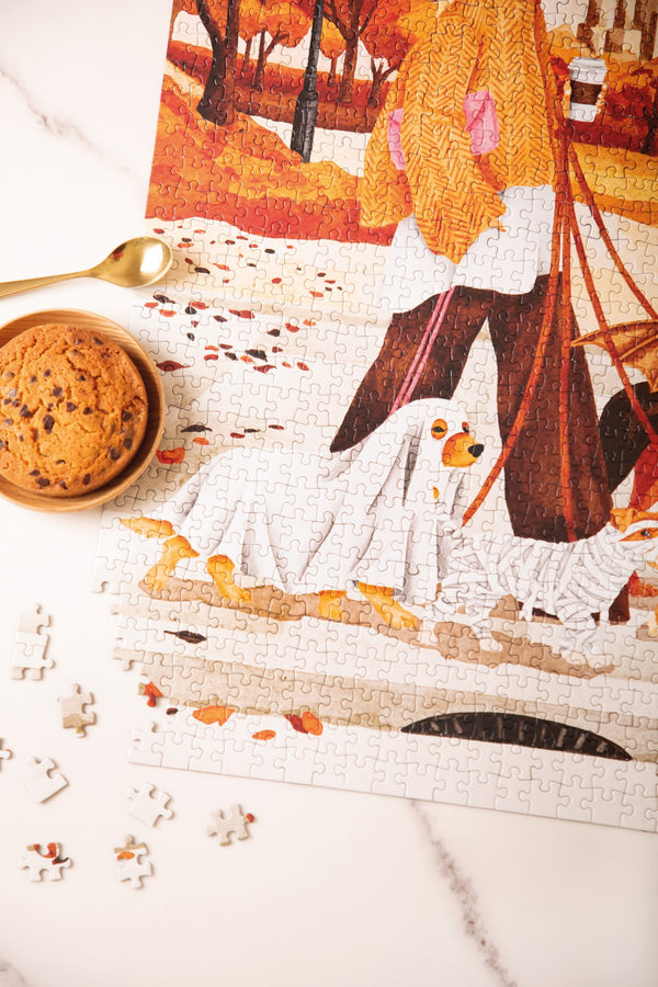 Close-up of the October Walks puzzle showing a dog in a ghost costume and a dog dressed as a mummy, next to a cookie
