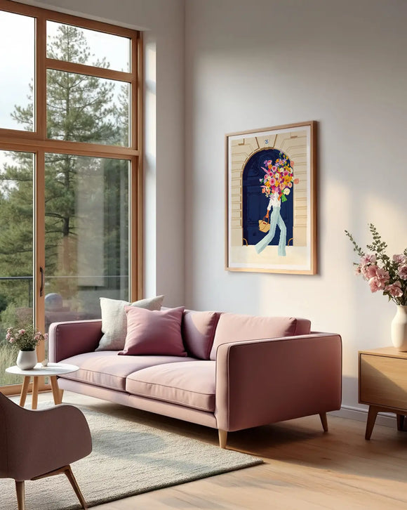 A framed Parisian Door art print displayed in a bright modern living room with a pink sofa and large window view.