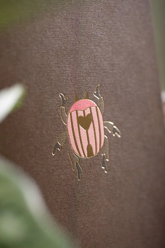 Pink Croco Pocket Notebook A6 DUO - Detailed view of the gold foil beetle on the brown notebook.