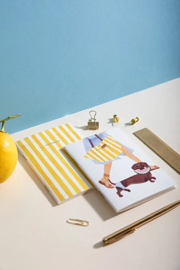 Summer Dachshund Pocket Notebook A6 DUO - High angle view with a lemon and golden office supplies.