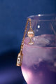 Duo Rose All Day Chain - Pins: the gold chain pin set styled with a purple cocktail on a dark blue background.