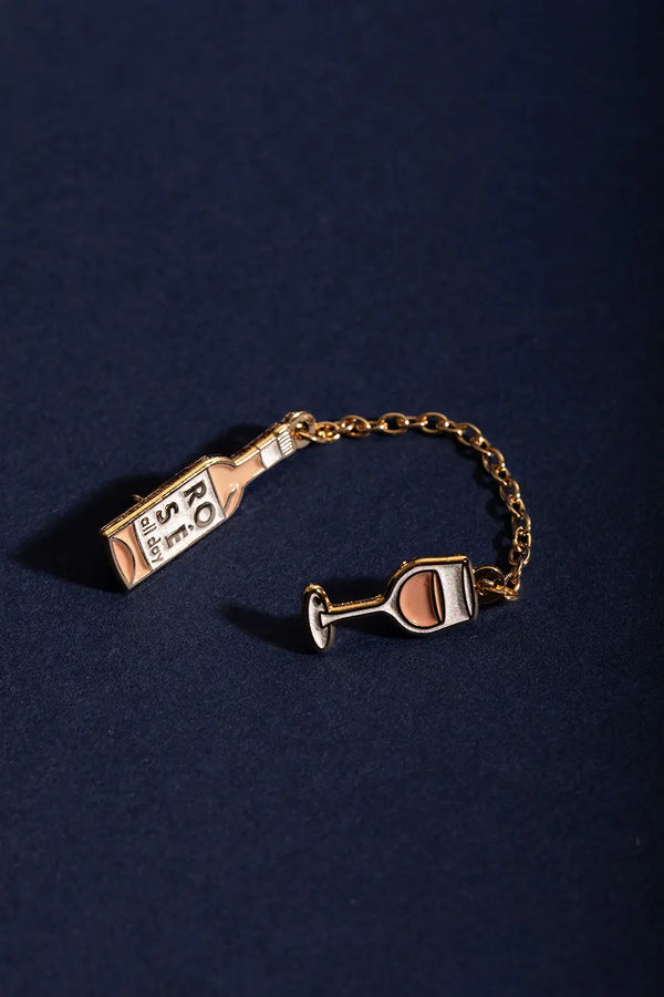 Duo Rose All Day Chain - Pins: top-down view of the connected bottle and glass pins on a navy surface.