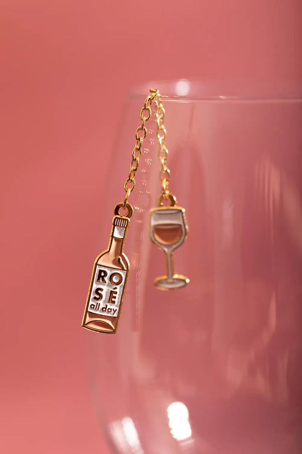 Duo Rose All Day Chain - Pins: close-up of the rosé bottle and glass pins hanging on a crystal wine glass.