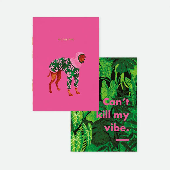Wet Season A6 pocket notebook duo covers by All The Ways To Say, one hot pink notebook featuring a dog in a leaf-print raincoat, the other featuring dense jungle foliage with "Can't kill my vibe." text in pink lettering