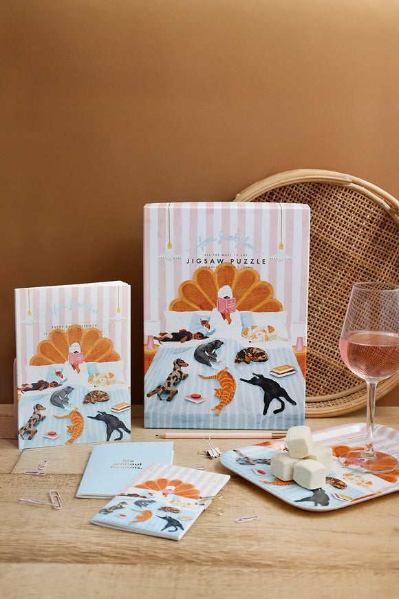 Home Sweet Home illustrated puzzle and notebook on wooden table with soft warm decor